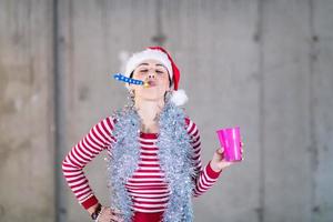 giovane attività commerciale donna indossare un' rosso cappello e soffiaggio festa fischio foto