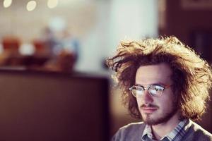 uomo Lavorando su computer nel buio ufficio foto