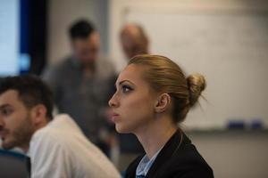 ritratto di giovane attività commerciale donna a ufficio con squadra su incontro nel sfondo foto