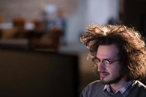 uomo Lavorando su computer nel buio ufficio foto