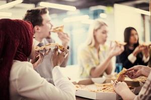 multietnico attività commerciale squadra mangiare Pizza foto