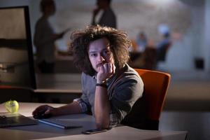 uomo Lavorando su computer nel buio ufficio foto