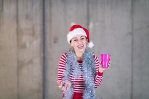 giovane attività commerciale donna indossare un' rosso cappello e soffiaggio festa fischio foto