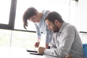 Due attività commerciale persone Lavorando con tavoletta nel avviare ufficio foto