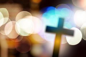 bellissimo bokeh con attraversare nel il sfondo, concetto per religione e preghiera foto