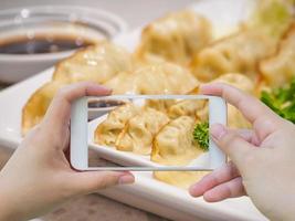 assunzione foto di gyoza Ravioli con smartphone