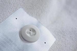 lavanderia cura capi di abbigliamento etichetta con pulsante su cotone camicia foto