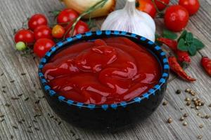 pomodoro ketchup nel un' ciotola su di legno sfondo foto