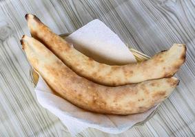 fatti in casa pane nel un' cestino su di legno sfondo foto