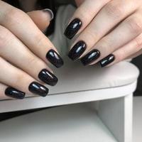 elegante di moda nero femmina manicure.mani di un' donna con nero manicure su Chiodi foto