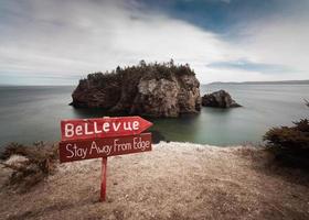 segnaletica di legno della spiaggia vicino allo specchio d'acqua foto