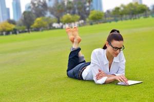 bellissimo giovane donna con tavoletta nel parco foto