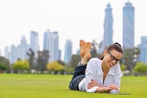 bellissimo giovane donna con tavoletta nel parco foto