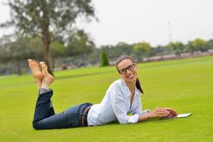 bellissimo giovane donna con tavoletta nel parco foto