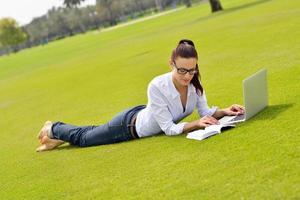 donna con il computer portatile nel parco foto