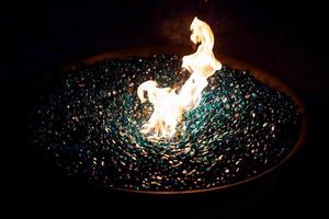 raggiante blu bicchiere rocce nel all'aperto, vicino su all'aperto camino con un' fiamma. foto