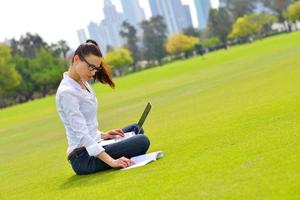 donna con il computer portatile nel parco foto