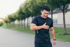 maschio asiatico atleta, ha il petto dolore fitness nel il parco e in esecuzione, cuore dolori dopo foto