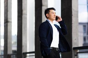 asiatico uomo d'affari parlando su il Telefono grave ha un arrabbiato conversazione foto
