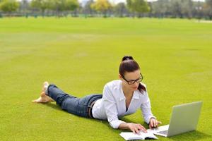 donna con il computer portatile nel parco foto