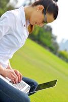 donna con il computer portatile nel parco foto