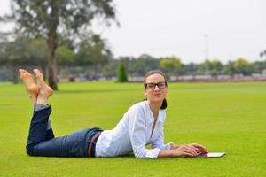 bellissimo giovane donna con tavoletta nel parco foto