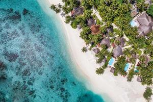 scenario paradisiaco delle maldive. paesaggio aereo tropicale, paesaggio marino con lungo molo, ville sull'acqua con splendida spiaggia di mare e laguna, natura tropicale. banner di destinazione turistica esotica, vacanze estive foto