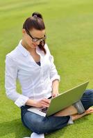 donna con il computer portatile nel parco foto