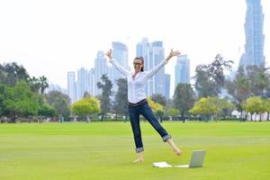 donna con il computer portatile nel parco foto