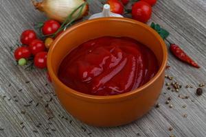 pomodoro ketchup nel un' ciotola su di legno sfondo foto