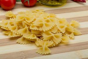 crudo farfalle su di legno tavola e di legno sfondo foto