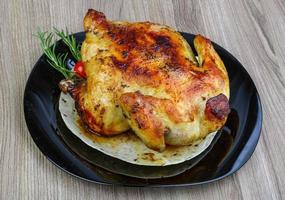 grigliato pollo su il piatto e di legno sfondo foto