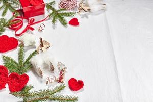 Natale sfondo con regalo scatole, nastro, spago, carta rotoli, a maglia cuori e Natale ornamento. foto