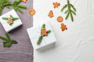 Natale i regali avvolto nel bianca carta e decorato con abete rosso rametti e Pan di zenzero biscotti foto