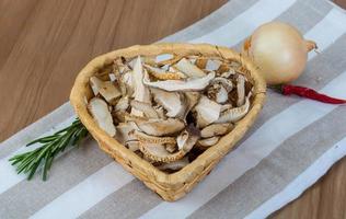 asciutto shiitake nel un' cestino su di legno sfondo foto