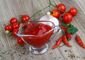 pomodoro ketchup nel un' ciotola su di legno sfondo foto