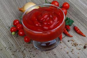 pomodoro ketchup nel un' ciotola su di legno sfondo foto