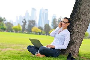 donna con il computer portatile nel parco foto