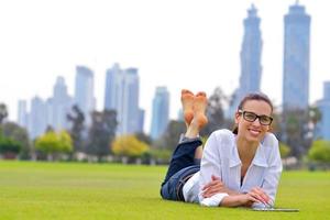 bellissimo giovane donna con tavoletta nel parco foto