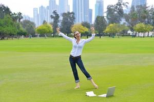 donna con il computer portatile nel parco foto