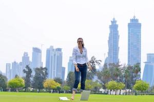 donna con il computer portatile nel parco foto