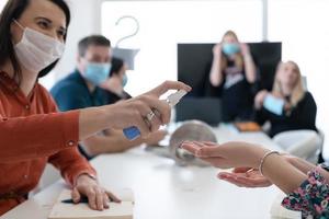 nuovo normale uomini d'affari su incontro utilizzando antibatterico mano disinfettante foto
