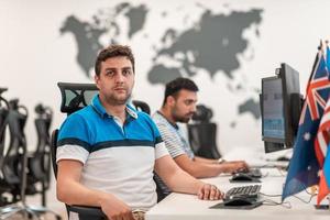 gruppo di casuale attività commerciale uomo Lavorando su del desktop computer nel moderno Aperto Piano avviare ufficio interno. selettivo messa a fuoco foto