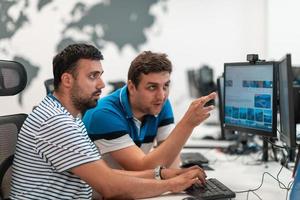 gruppo di casuale attività commerciale uomo Lavorando su del desktop computer nel moderno Aperto Piano avviare ufficio interno. selettivo messa a fuoco foto