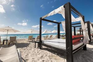 lettini di lusso in legno sulla spiaggia caraibica