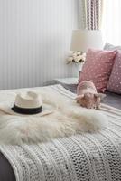 cuscini rosa con bambola rosa sul letto in legno bianco