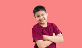 ritratto di poco asiatico ragazzo ragazzo in piedi sorridente con braccia attraversato fiducioso gesto su un' bianca sfondo foto