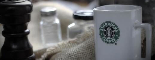 Washington - Stati Uniti d'America settembre, 26 2022 Starbucks caffè boccale su grigio tavolo con caffè bottiglia e caffè macinino. foto