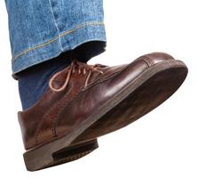 passo di maschio giusto gamba nel jeans e Marrone scarpa foto