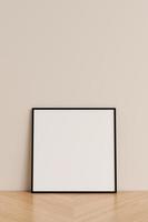 pulito e minimalista davanti Visualizza piazza nero foto o manifesto telaio modello pendente contro parete su di legno pavimento. 3d resa.